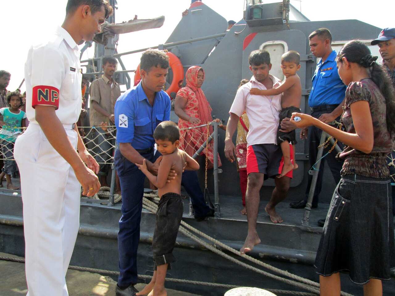 Would-be asylum seekers to Australia are helped off a Sri Lankan naval craft on July 31, 2013 after their boat was intercepted off the island's eastern coast.
