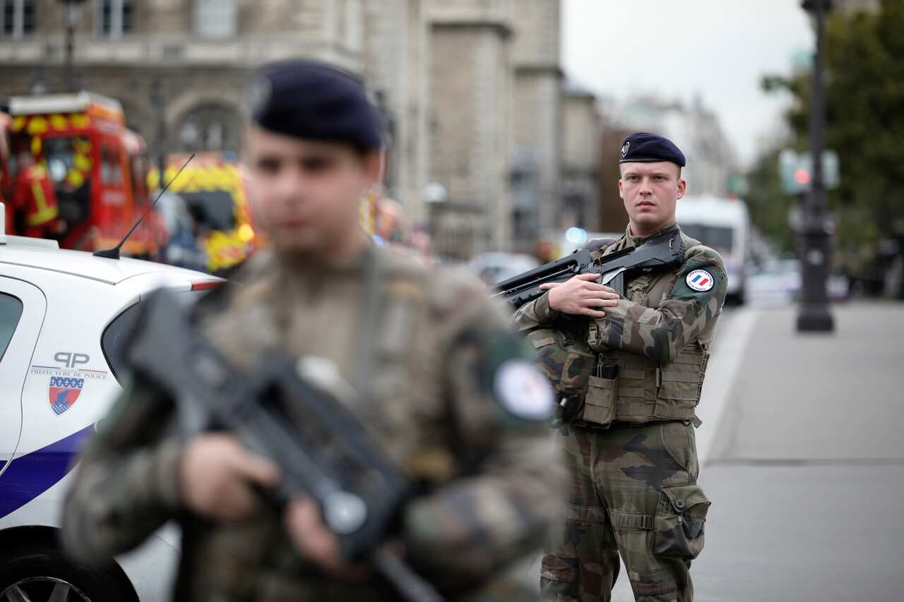 Armed soldiers patrol after an incident at the police headquarters in Paris.