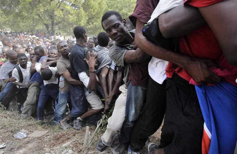People try to stay in line to get disaster relief supplies in the aftermath of the earthquake in Port-au-Prince, Haiti in 2010