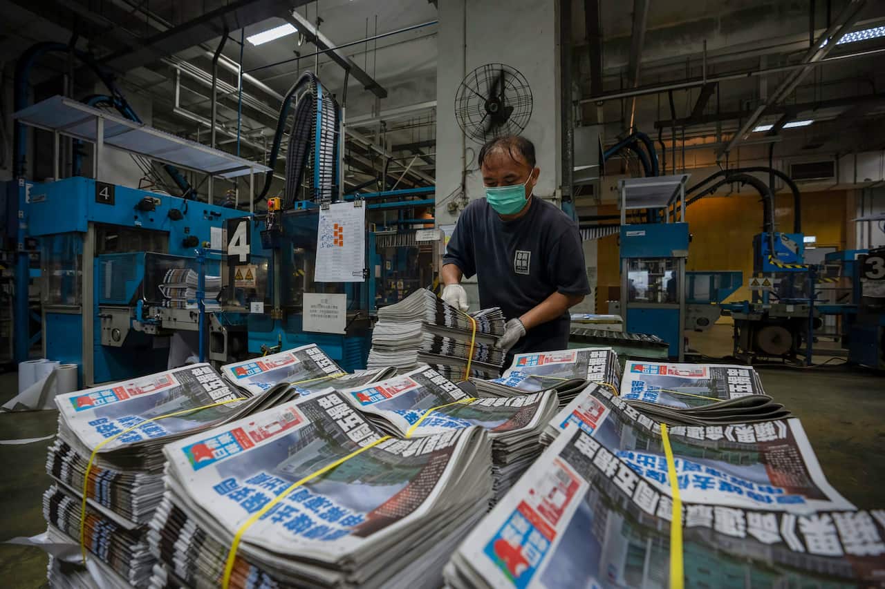 An employee stacks freshly printed newspapers onto a pallet in the Apple Daily printing facility in Hong Kong.