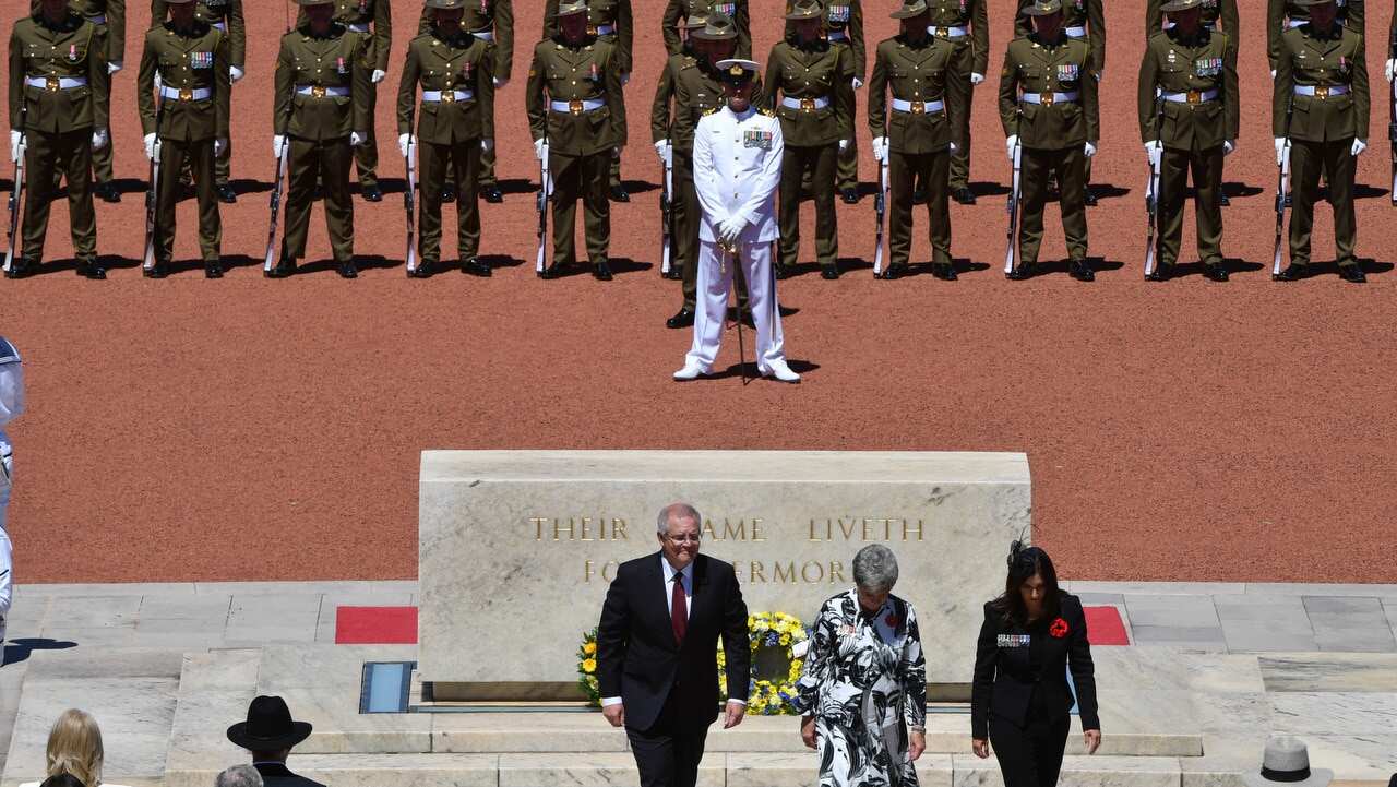 Prime Minister Scott Morrison and war widows Meg Green and Gwen Cherne lay wreaths during Remembrance Day at the Australian War Memorial, in Canberra.