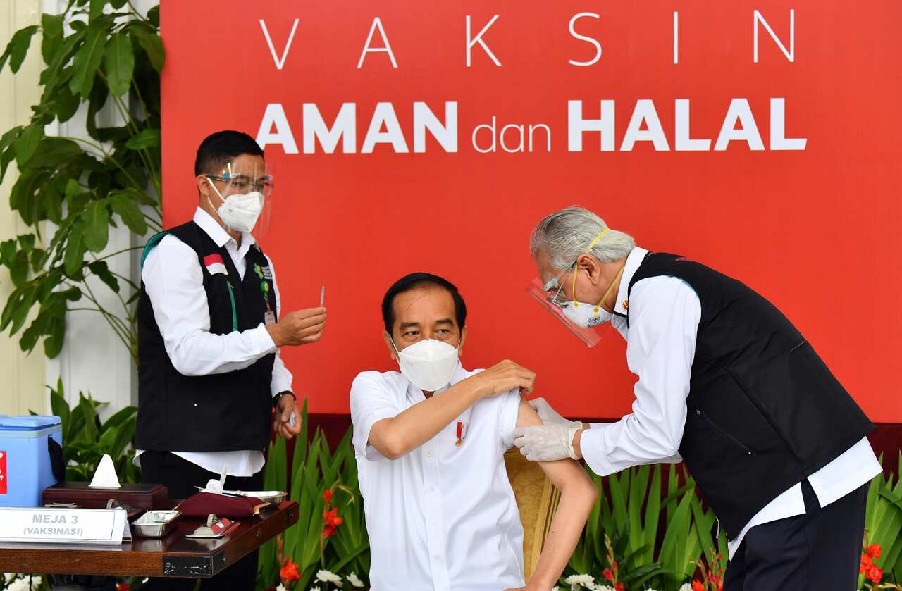Indonesian President Joko Widodo rolls up his sleeve to receive a COVID-19 vaccine on live television.