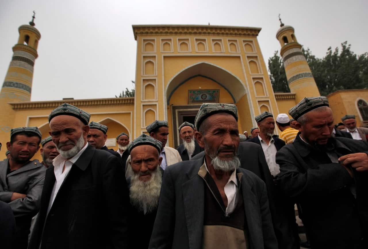 Muslim men of the Uighur ethnic group leave the Id Kah Mosque after Friday prayers in Kashgar, Xinjiang