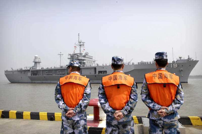 Soldiers from the Chinese People's Liberation Army (PLA) Navy watch as the USS Blue Ridge arrives at a port in Shanghai, Friday, May 6, 2016