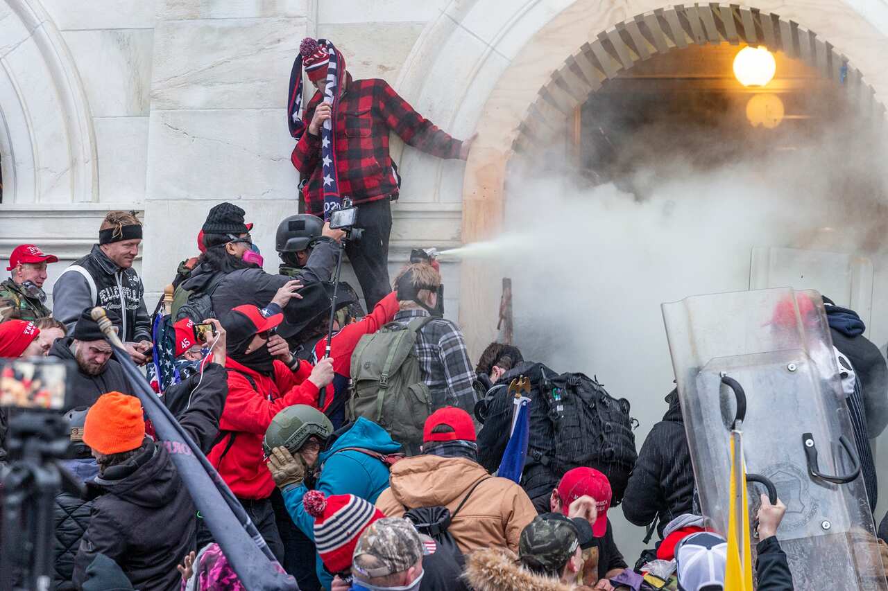 Rioters use tear gas while clashing with police trying to