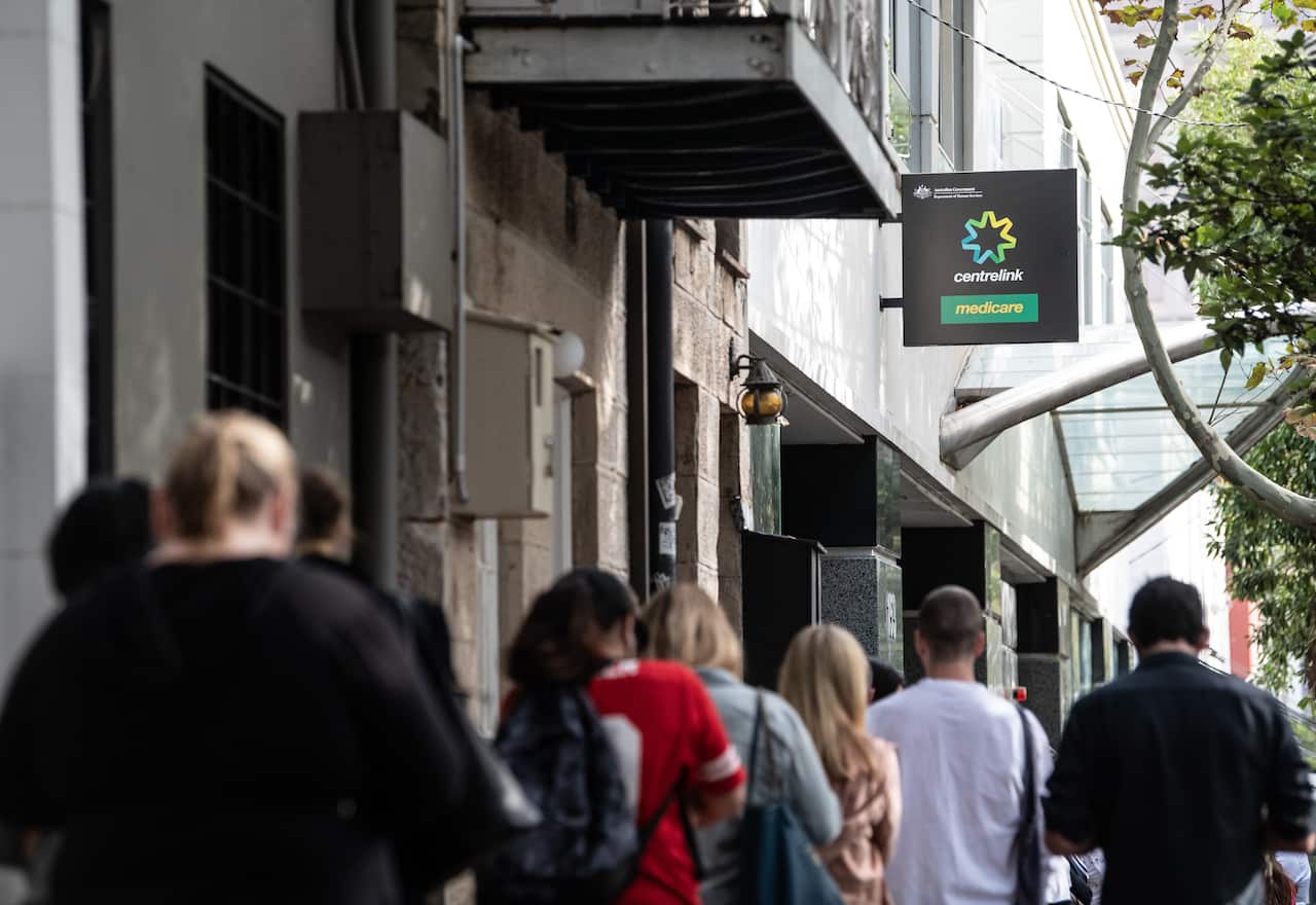 People queue for access to a Centrelink Service Centre in Sydney.