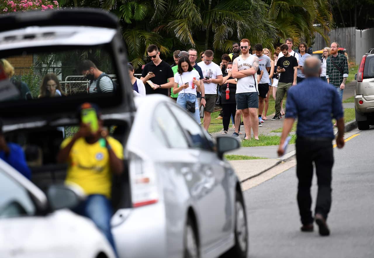 People are seen in a long queue outside a Centrelink office in Brisbane.