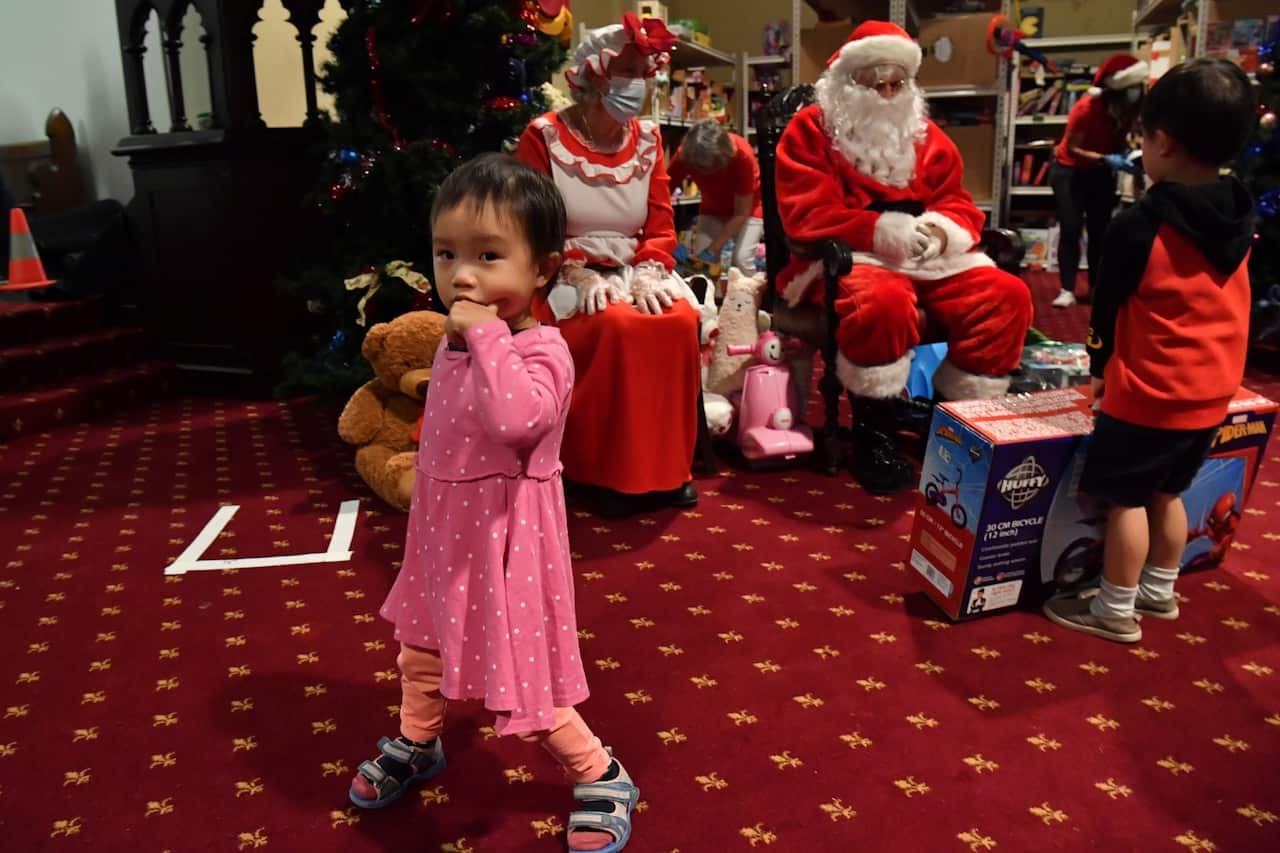 The children of needy families are give Christmas presents by Santa Clause at the Reverend Bill Crews Foundation at Ashfield in Sydney.