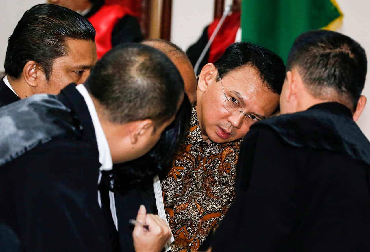 Jakarta's governor Basuki Tjahaja Purnama popularly known as 'Ahok' (C) talks to his lawyers inside the courtroom during his blasphemy trial