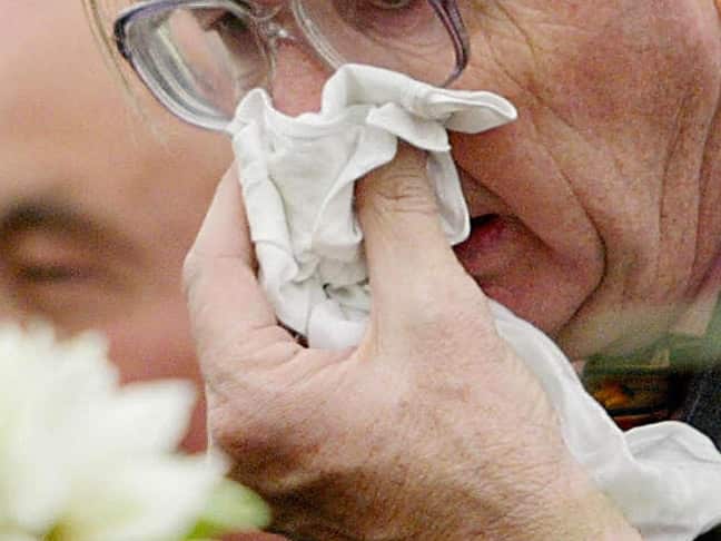 Elderly person blows nose