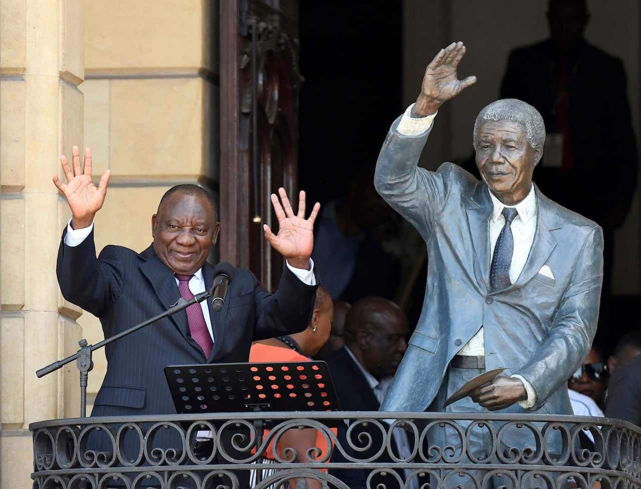 South African President Cyril Ramaphosa, left, next to a sculpture of former President Nelson Mandela.