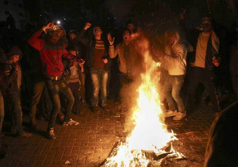 Palestinians burn tyres during a protest against U.S. President Donald Trump's decision to recognise Jerusalem as the capital of Israel, at the main Square in Gaza City, Thursday, Dec. 7, 2017