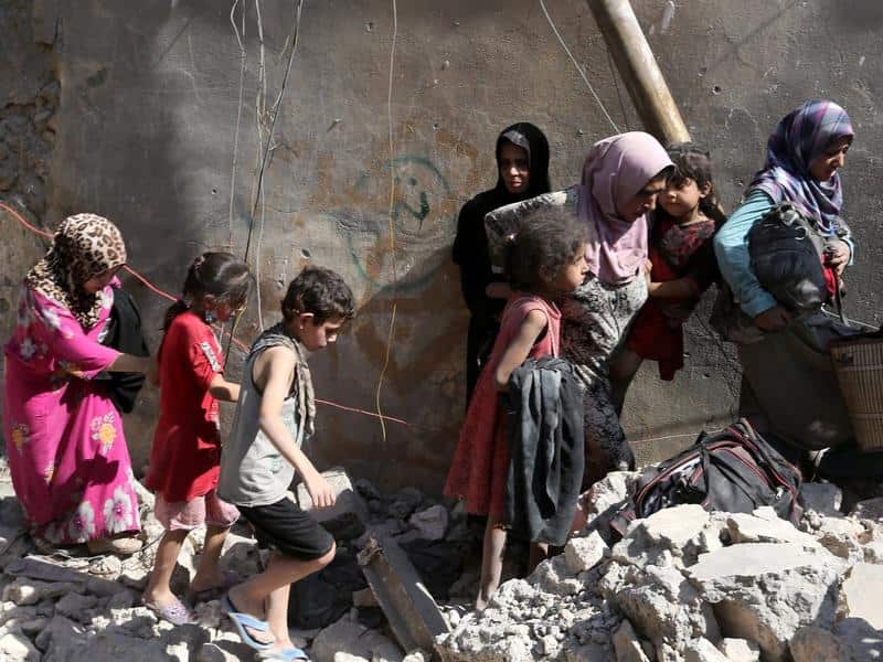 People walk among the ruins of Mosul