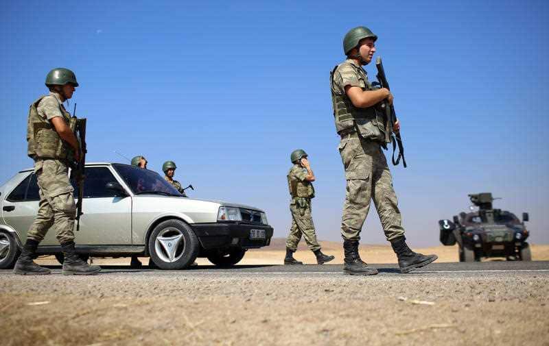 Turkish soldiers take position on a road near Suruc on the border with Syria as a convoy of vehicles with Abdullah Kurdi, the Syrian man who survived a capsizing during a desperate voyage from Turkey to Greece takes the bodies of his wife and two sons for