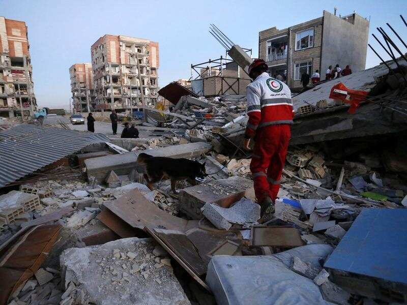 A rescue worker searches debris for survivors