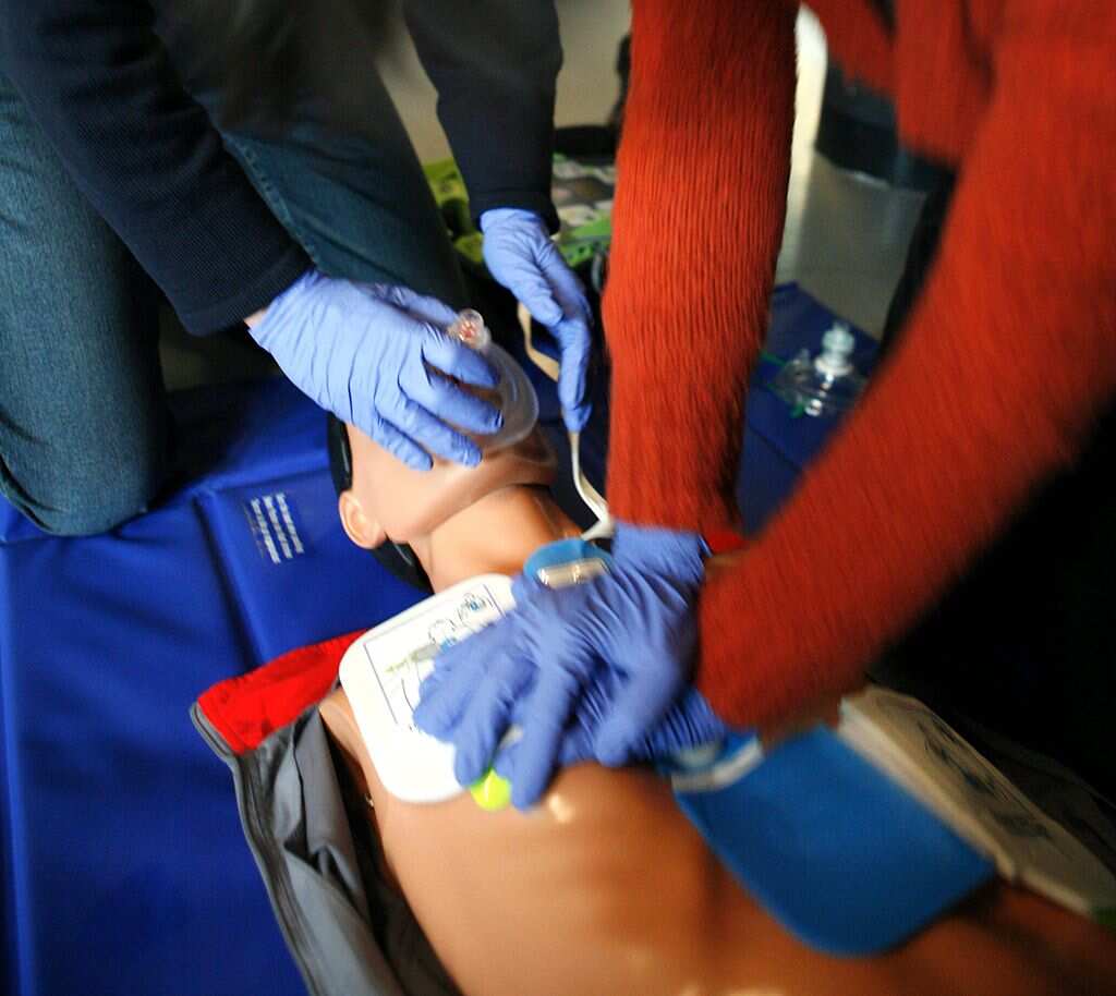 People practising CPR on a mannequin