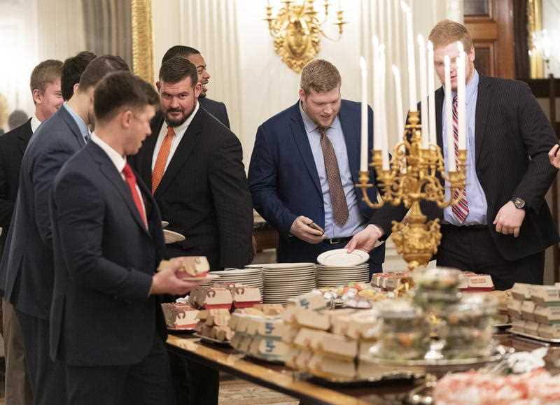 Guests attending a reception for the Clemson Tigers grab fast food sandwiches in the State Dining Room of the White House.