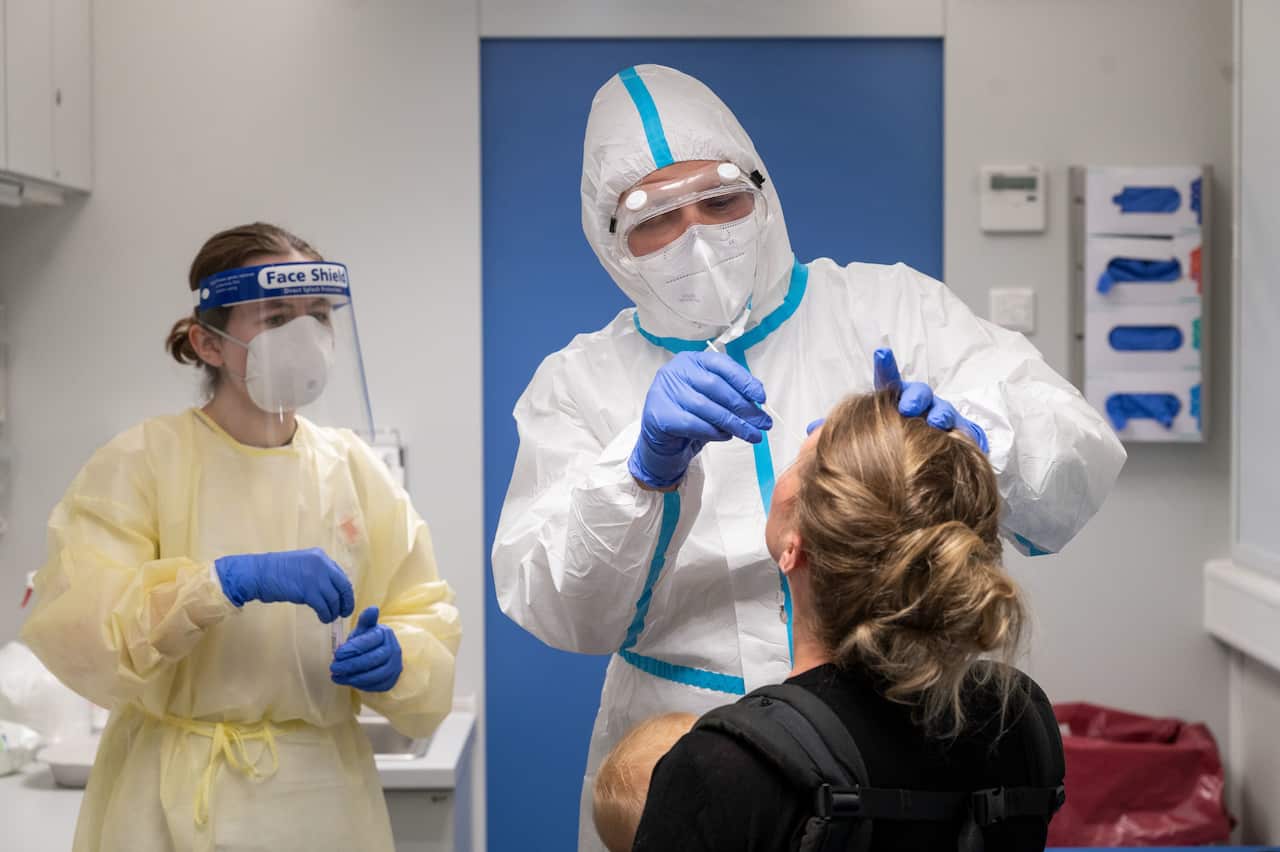 A traveller who has been in Switzerland gets tested by medic at a coronavirus testing centre at the main railway station in Stuttgart, Germany.