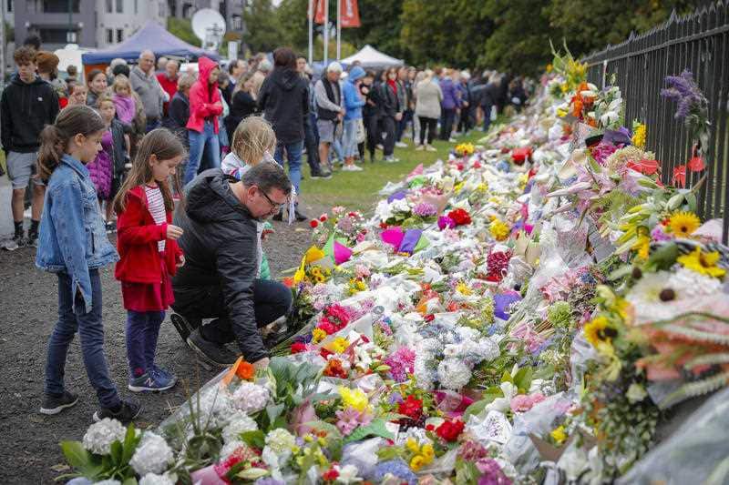 Mourners lay flowers on a wall at the Botanical Gardens in Christchurch.
