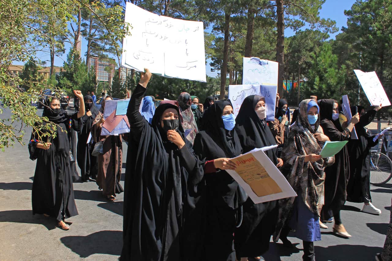 Afghan women hold placards as they take part in a protest in Herat on Septembe
