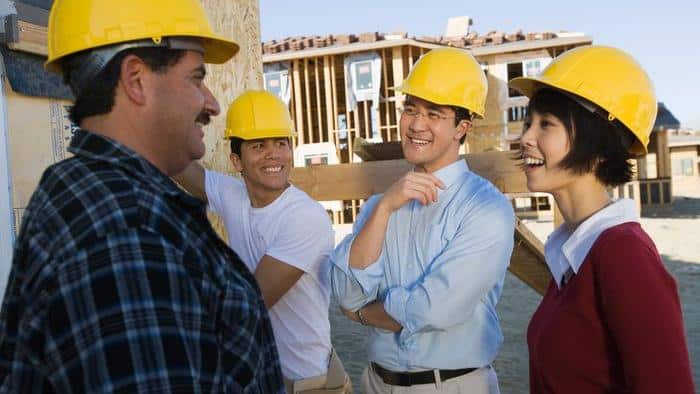 Smiling couple with construction workers