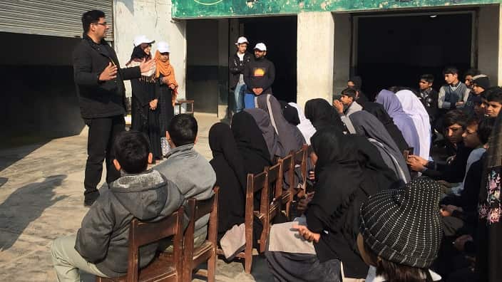 Dr Ashir Ahmed talking to the school children in the outskirts of Pakistan the importance of computer.