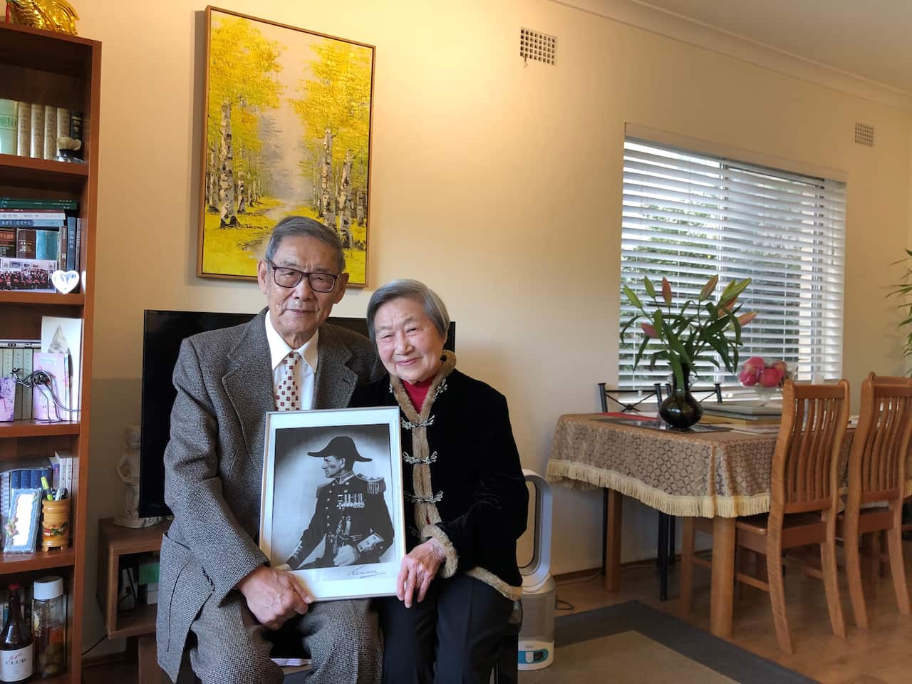  Mr. and Mrs. Joe holding a photograph of the captain of the HMS Waalmongo