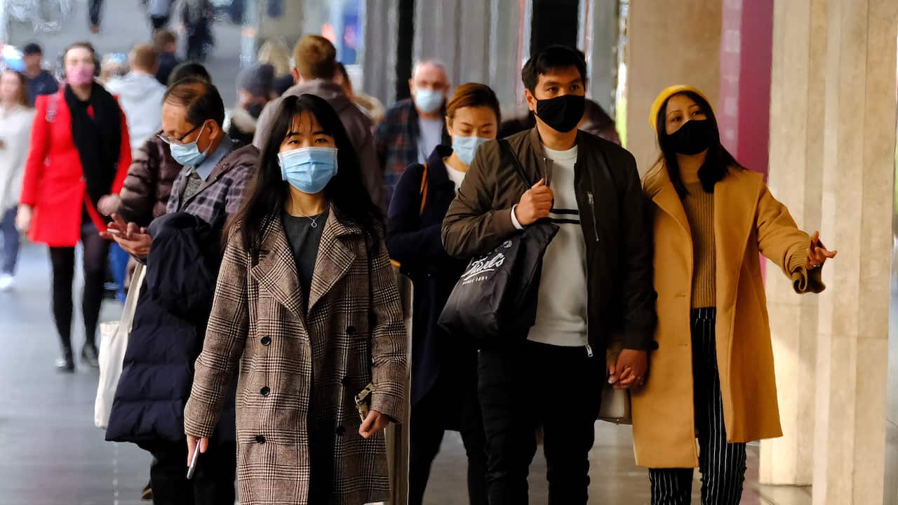 People wearing face masks walk in the Melbourne CBD, Thursday, July 15, 2021. Victoria has reported two new locally acquired COVID-19 cases, on top of the 10 reported in Thursday's official figures. (AAP Image/Luis Ascui) NO ARCHIVING