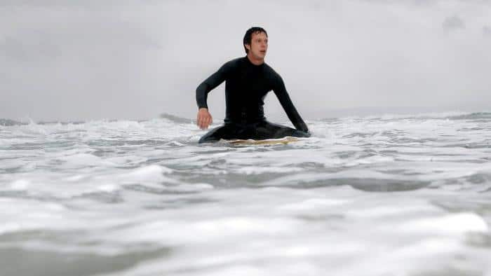 Young man on surfboard in ocean