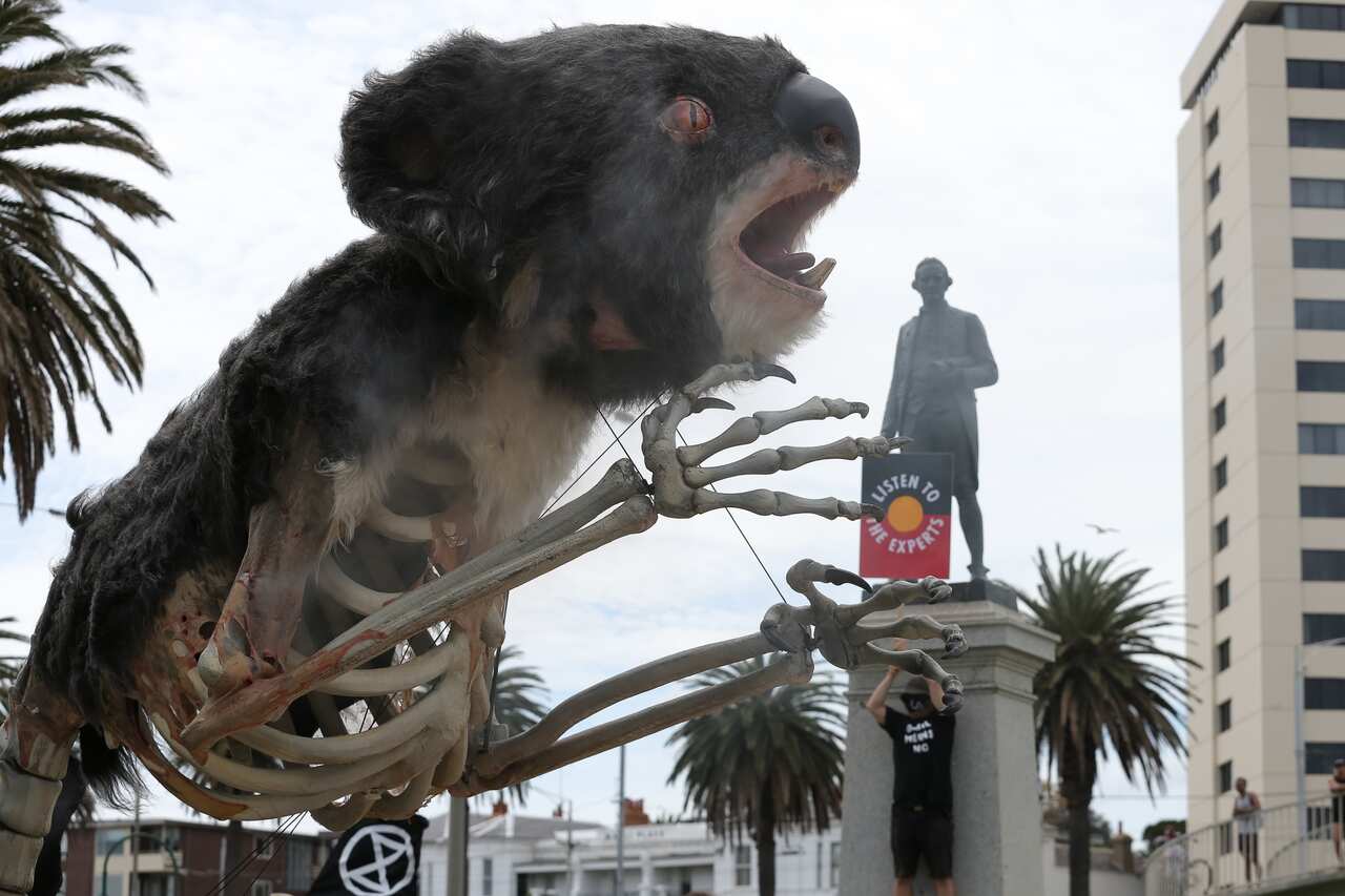 A Captain James Cook statue is seen as activists participate in an Extinction Rebellion protest in Melbourne, Saturday, November 6, 2021. (AAP Image/Con Chronis) NO ARCHIVING