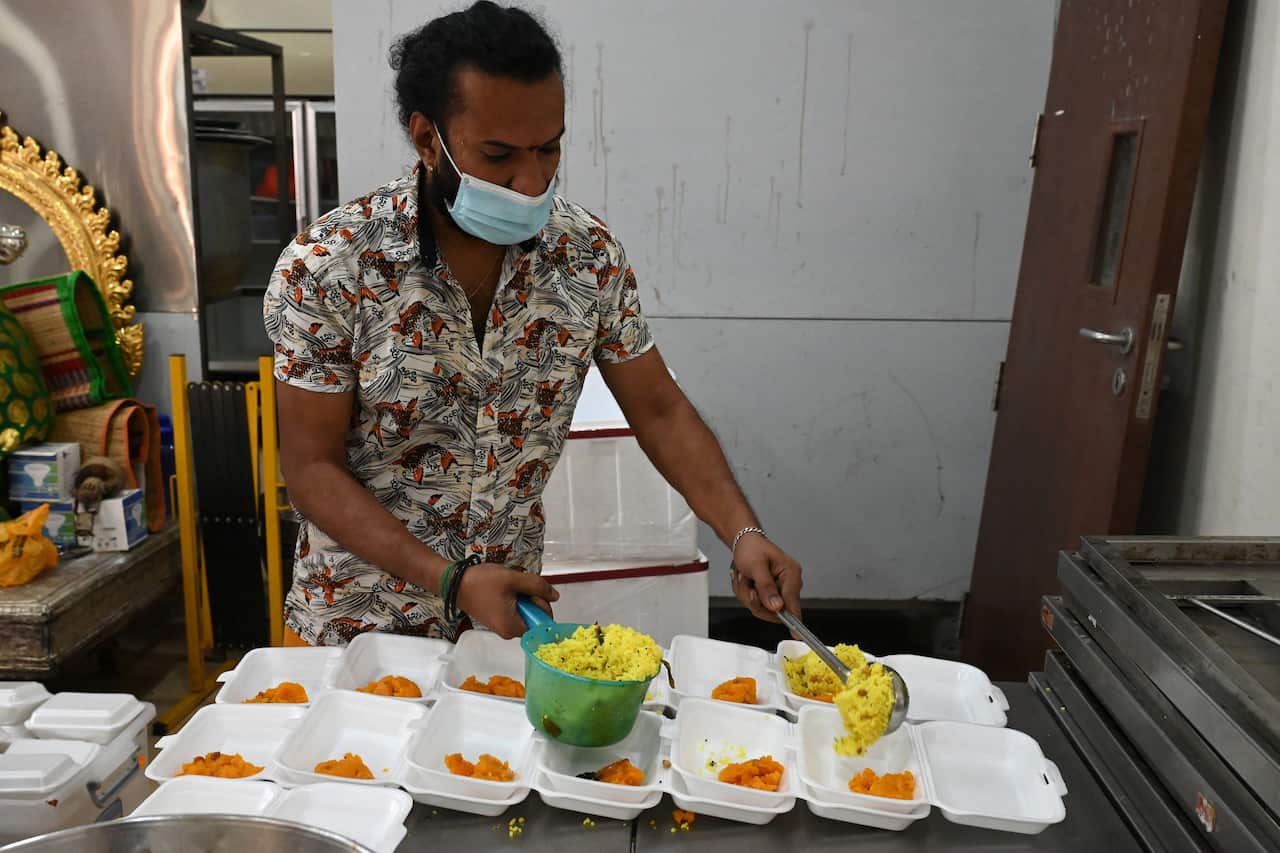 A member of the Sri Veeramakaliamman temple prepares lemon rice for migrant workers visiting for prayers in the district of Little India in Singapore on September 15, 2021,