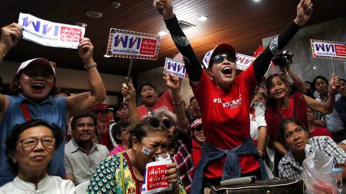 Supporters of Pheu Thai Party cheer the voting result after the general election closed at the party headquarters in Bangkok.