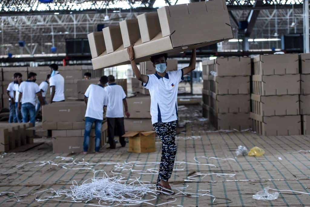 Workers arranging cardboard beds inside a coronavirus care centre in New Delhi, India.