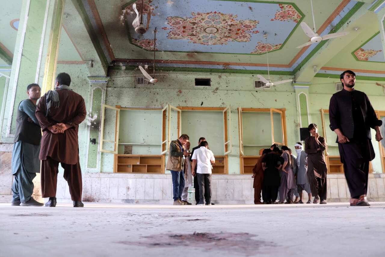 People inspect the scene of the bomb blasts