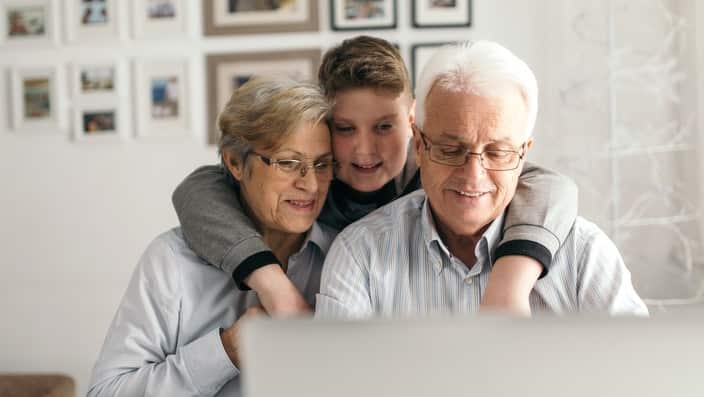 Grandparents and their grandchild at a computer