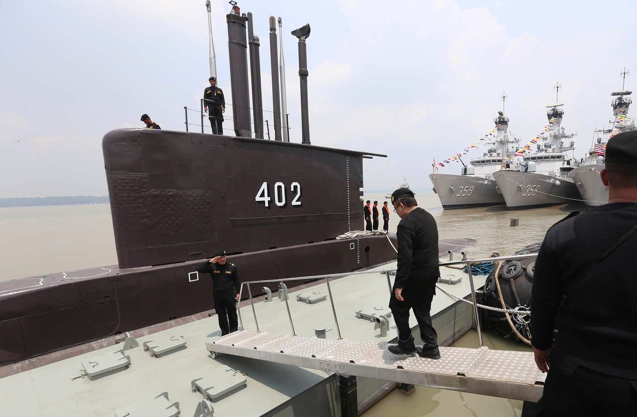 A crew of Indonesian Navy submarine KRI Nanggala as an officer walks aboard, at base of the Eastern Fleet Command in Surabaya, East Java, Indonesia