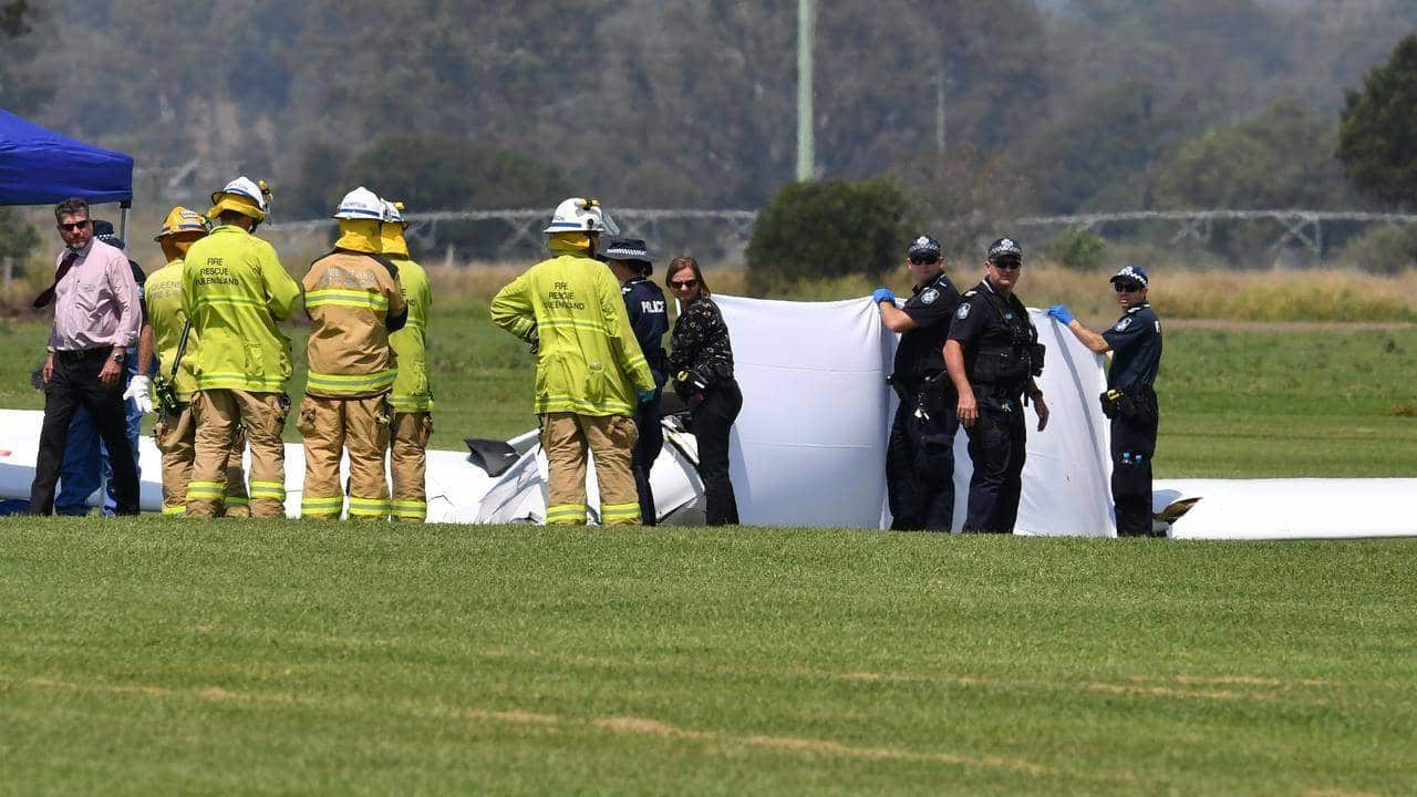 Two people are dead after a light plane crash in southeast Queensland with photos from the scene showing the wreckage lying on grass.