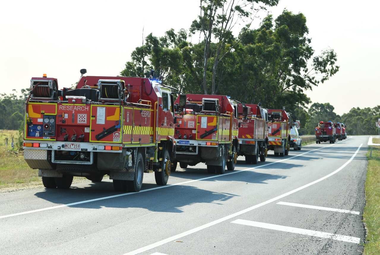 Fire Trucks stand by before deployment at a road closure checkpoint along the Princess freeway outside Pakenham Victoria, Sunday, March 3, 2019.