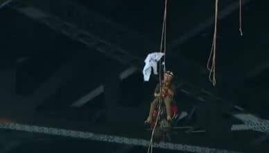 A Greenpeace protester tries to roll out his sign as he hangs from the bridge.