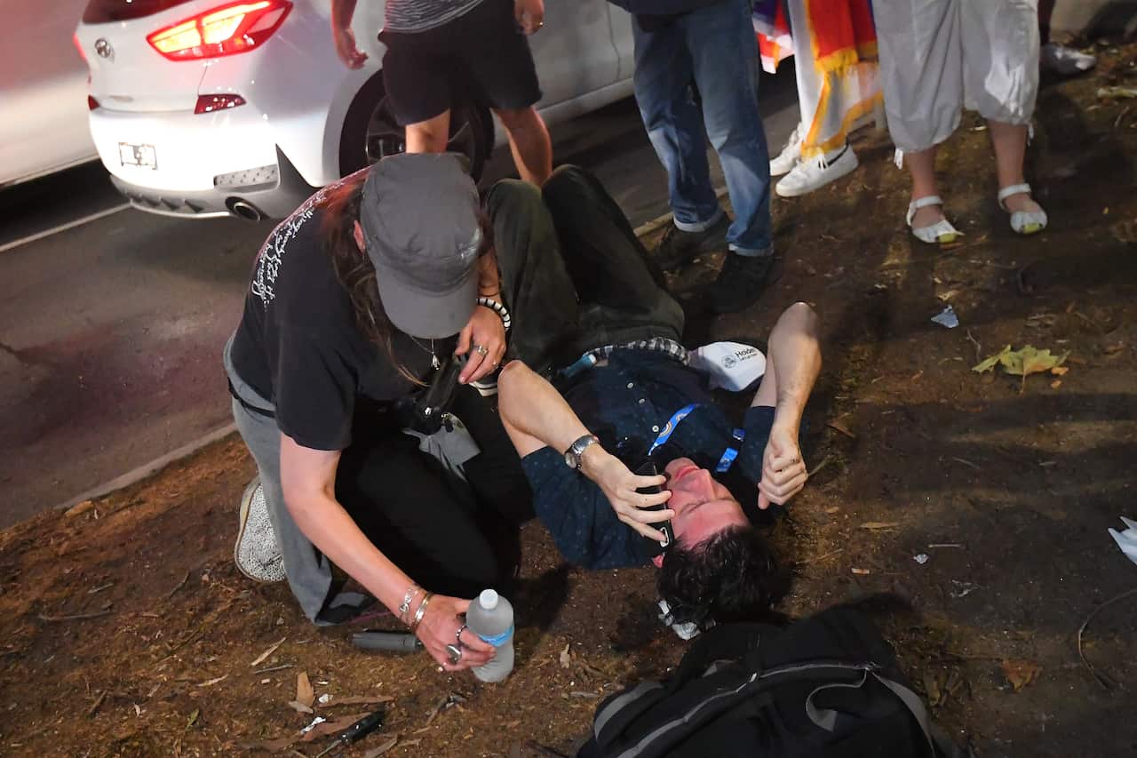 A member of the press (right) is seen on the ground after sustaining an injury during the protest.