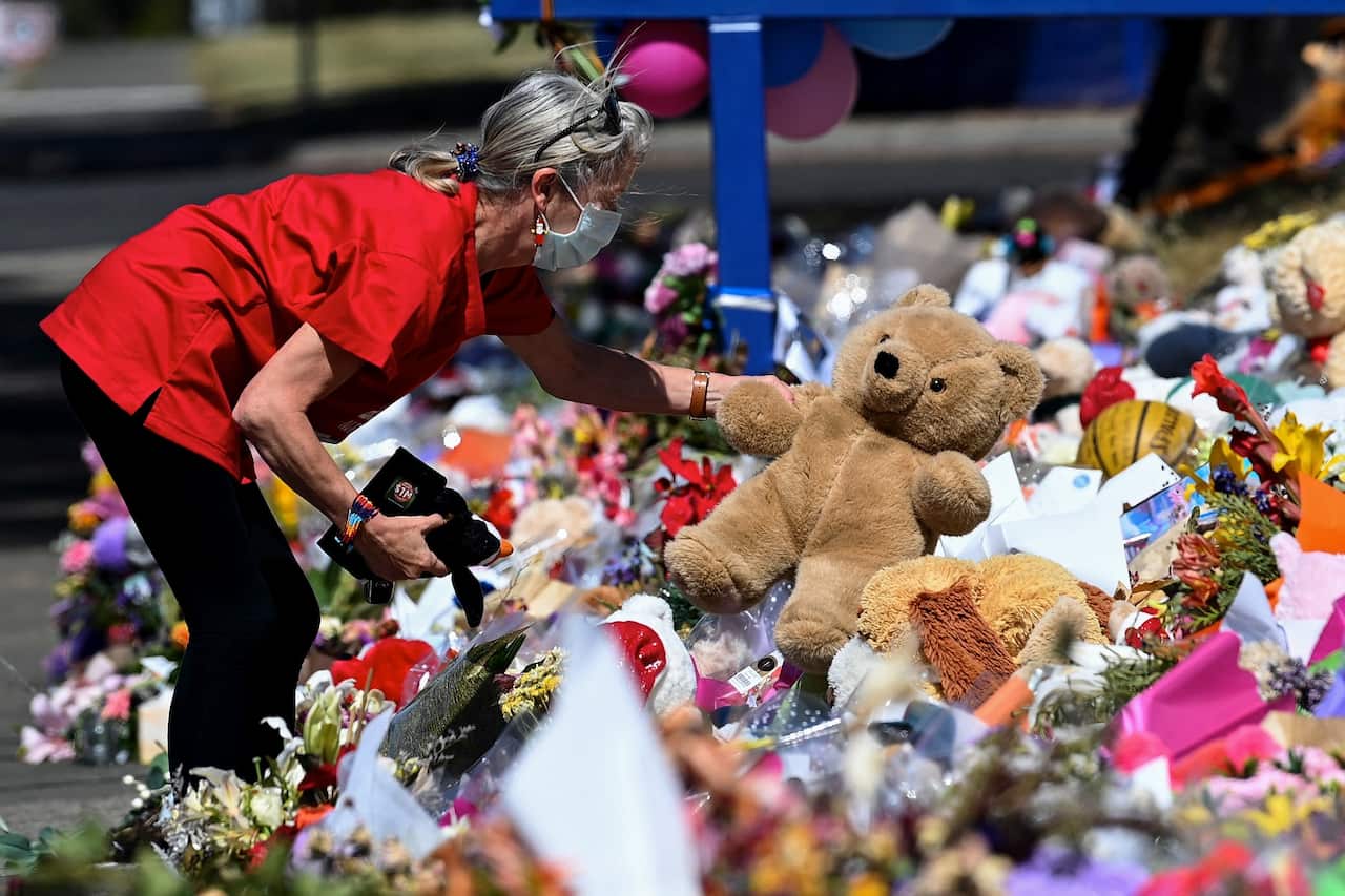 Members of the public place tributes outside Hillcrest Primary School in Devonport.