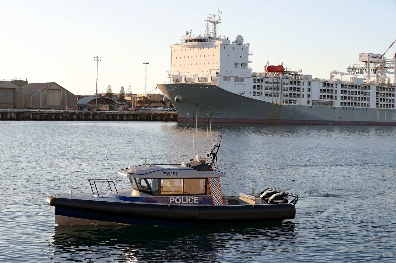 A police boat oversees sheep being loaded onto the Al Kuwait live export ship in Fremantle harbour, 16 June 2020. 