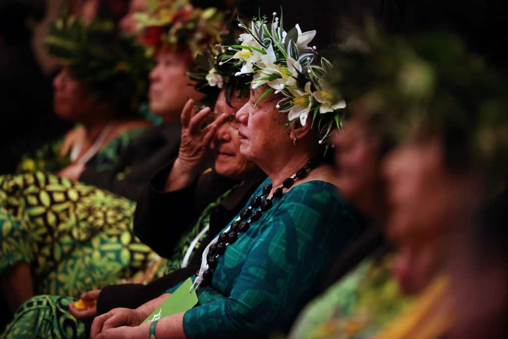 Guests listen as Jacinda Ardern makes the apology