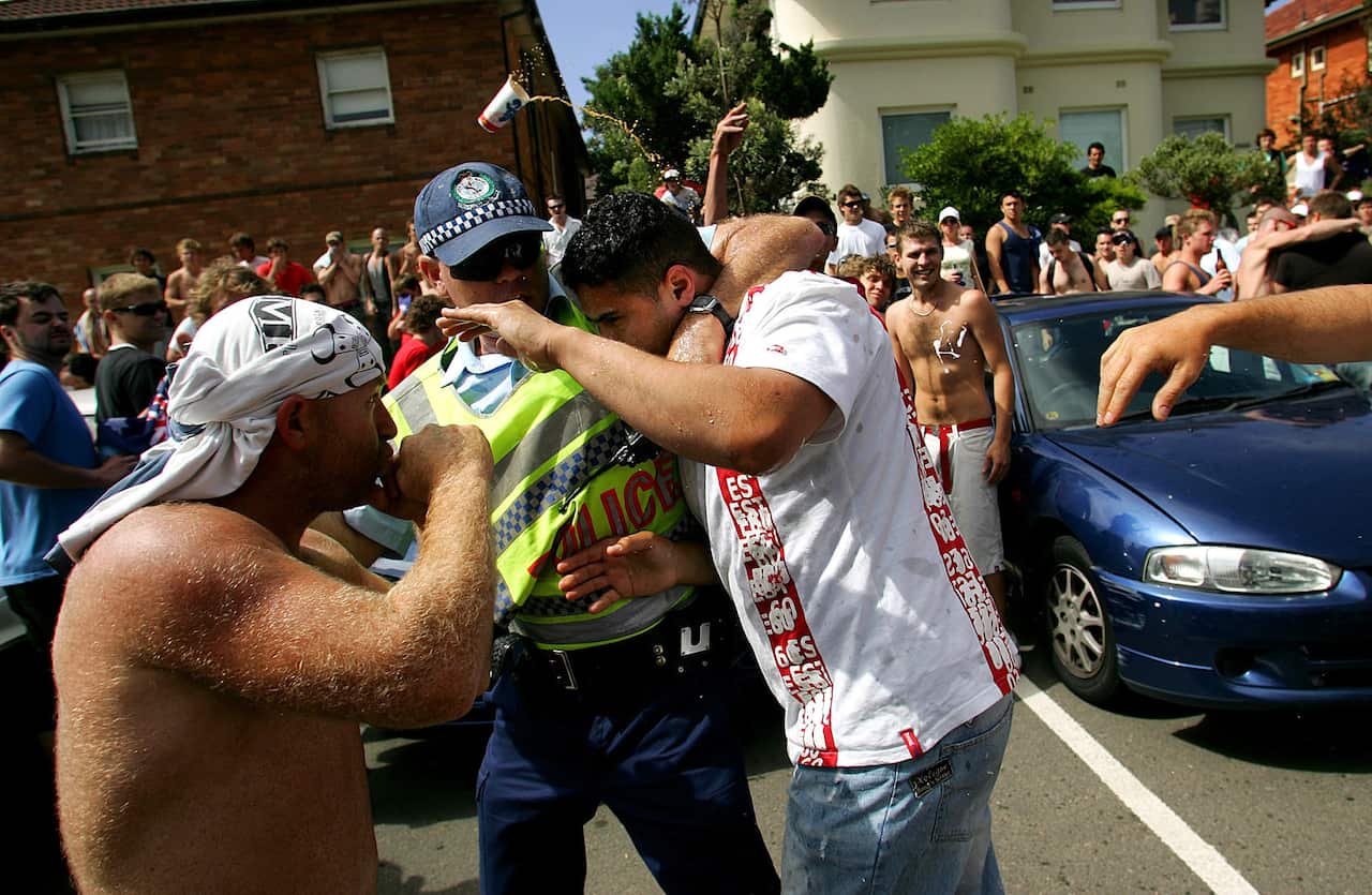 A police officer tries to protect a man from being punched during the Cronulla riots.