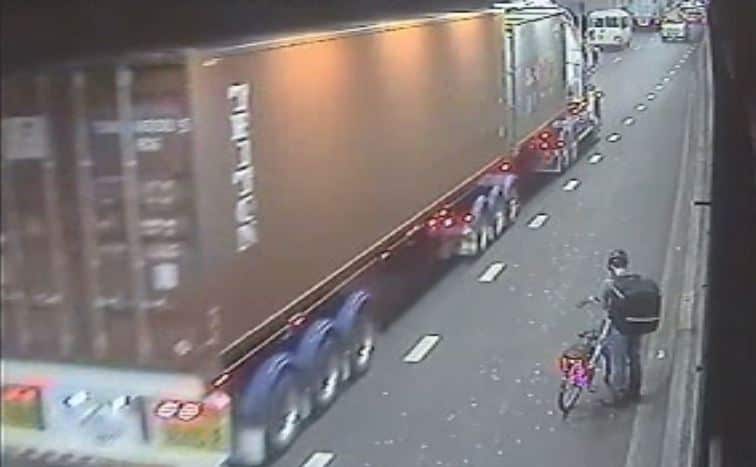 A food delivery cyclist is seen on CCTV in Sydney’s Eastern Distributor tunnel as a truck passes. 