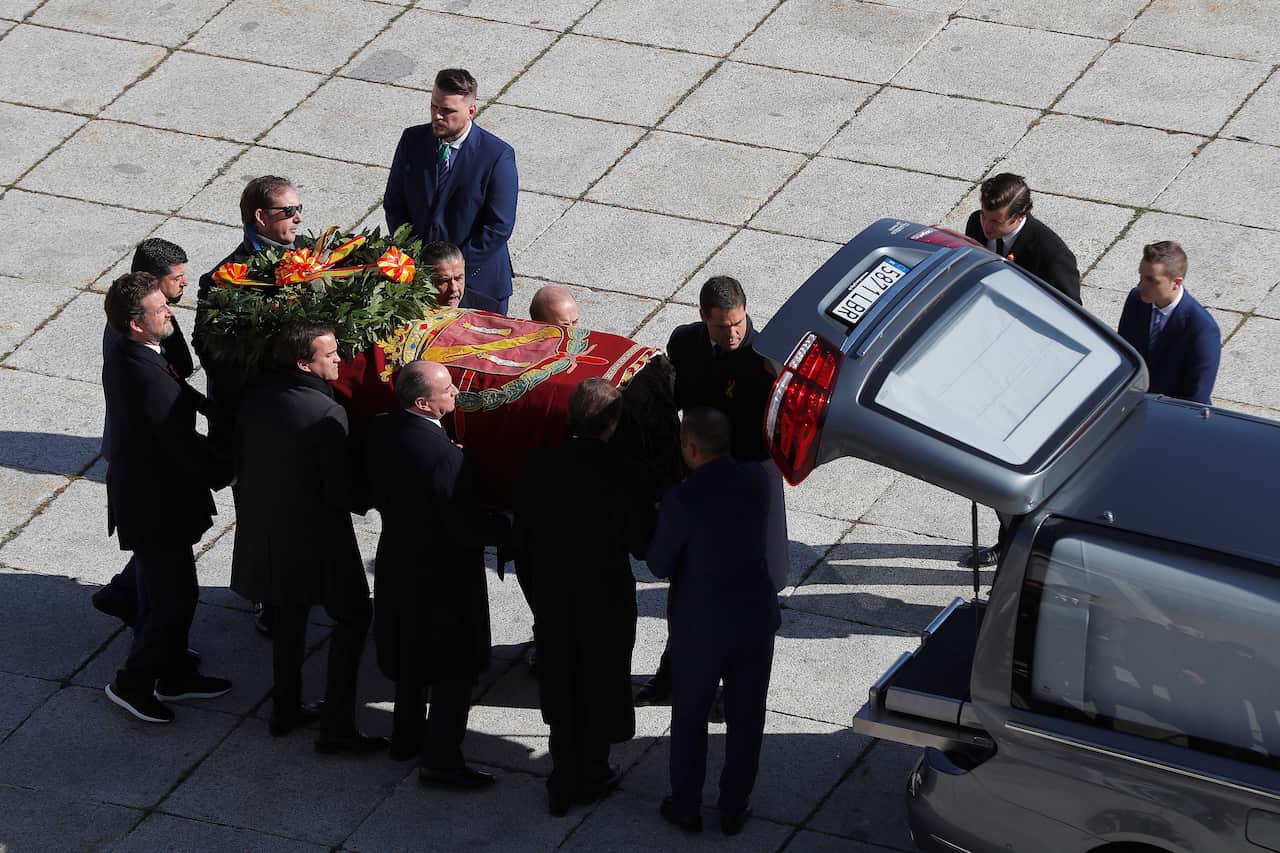 Relatives of late dictator Francisco Franco load his coffin into a funeral car.