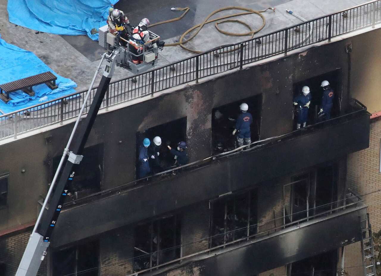 Kyoto police officers investigate at a three-story Kyoto Animation building, where a man set fire with liquid to kill 33 people and injure 35, in Kyoto.