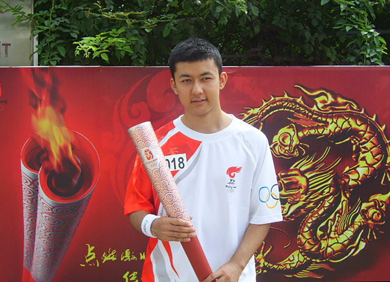 Kamaltrk Yalqun stands with an aluminium Olympic torch after running the relay to help carry the flame for the 2008 Beijing Olympics