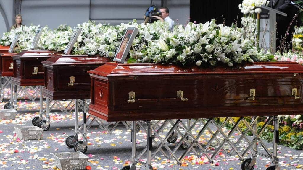 Caskets stand next to each other during the Lin family funeral.
