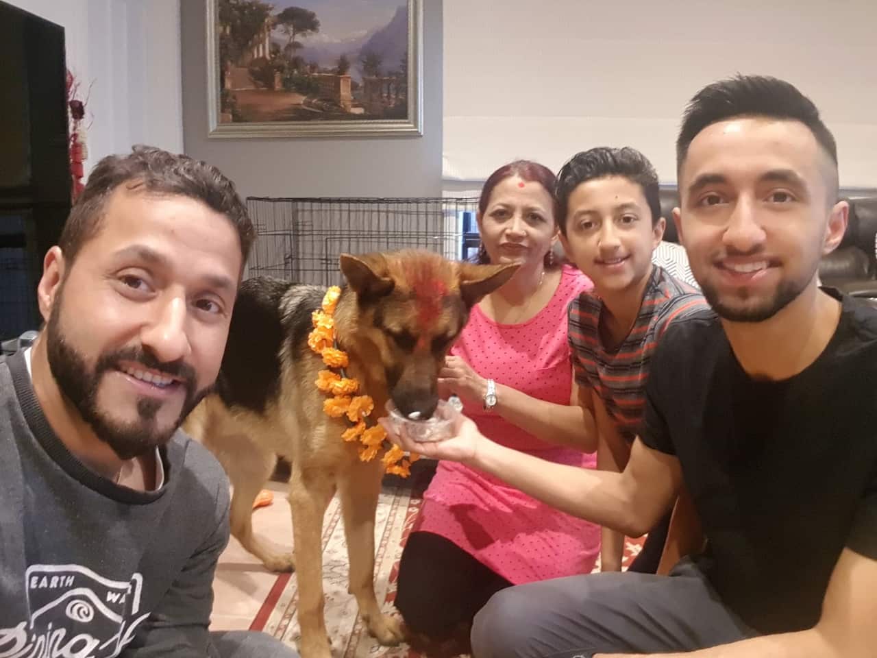 Melbourne resident Bhim Neupane (left) celebrating Kukur Tihar with German Shepherd Bruce and his family.
